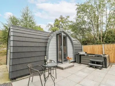 a small grey shed with a table and a grill at Oak View in Rhayader