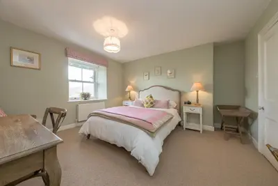 a bedroom with a bed and a table and a window at Cefn-Y-Maes in Dolgellau