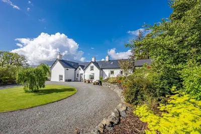 a large white house with a gravel driveway at Cefn-Y-Maes in Dolgellau