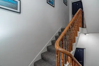a staircase in a home with wooden railings at Hafan-Glan-Mor in Barmouth