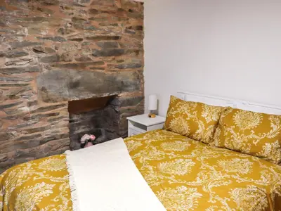 a bedroom with a bed and a stone wall at Apartment One - Uk49591 in Bala