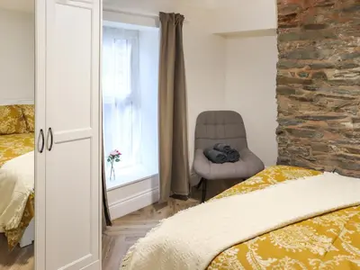 a bedroom with a bed and a chair and a window at Apartment One - Uk49591 in Bala