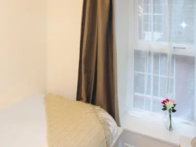 a bedroom with a window with a flower in a vase at Apartment One - Uk49591 in Bala