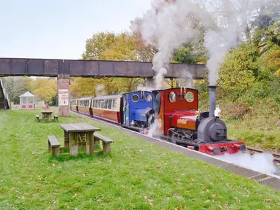 a train traveling down the tracks with smoke coming at Apartment One - Uk49591 in Bala