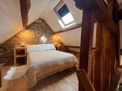 a bedroom with a large bed in a attic at The Hayloft at Cwmffrwd Farm in Cathedine