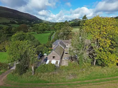 an old house in the middle of a field at The Hayloft at Cwmffrwd Farm in Cathedine