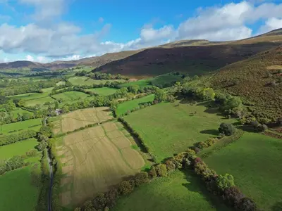 an aerial view of a field in the hills at The Hayloft at Cwmffrwd Farm in Cathedine