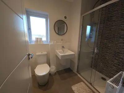a bathroom with a toilet and a sink and a shower at STYLISH & SPACIOUS 4 BEDROOM HOUSE - FREE DRIVEWAY PARKiNG in Shrewsbury
