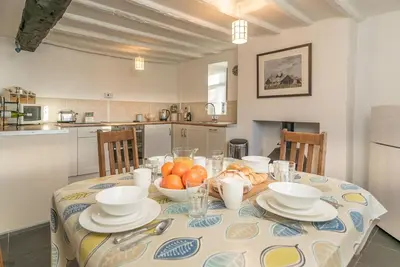a kitchen with a table with plates and bowls of fruit at Y-Felin in Dyffryn