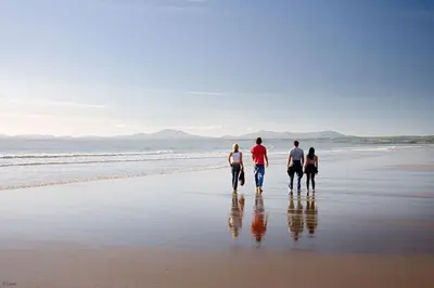 a group of three people walking on the beach at Y-Felin in Dyffryn