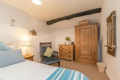 a bedroom with a bed and a chair and a wooden door at Y-Felin in Dyffryn