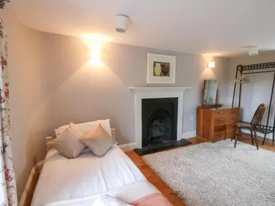 a bedroom with a bed and a fireplace at Secret Garden Cottage in Lampeter