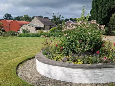a garden with a flower bed in a yard at Secret Garden Cottage in Lampeter