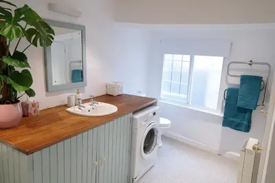 a bathroom with a sink and a washing machine at Pepper House Rooms - shared facilities - pet friendly in Ludlow
