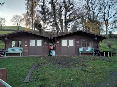 a small cabin with two benches in a yard at Alpaca Hideaway in Newtown