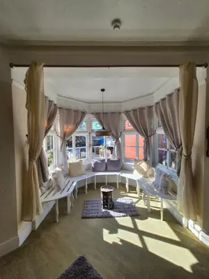 a living room with white furniture and windows at The Stokesay Inn in Craven Arms