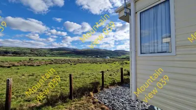 a building with a sign that reads welcome to a farm at Mountain view 039 in Barmouth