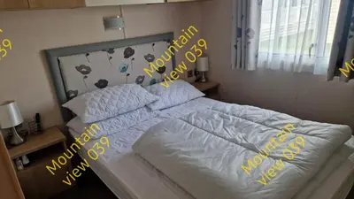 a bedroom with a bed with yellow writing on it at Mountain view 039 in Barmouth