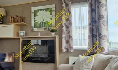 a living room with yellow signs on the wall at Mountain view 039 in Barmouth