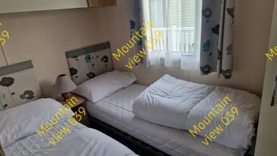 two beds in a room with yellow writing on the wall at Mountain view 039 in Barmouth