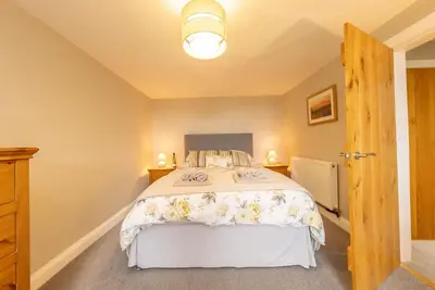 a bedroom with a bed with a white bedspread at Faeldre in Dyffryn