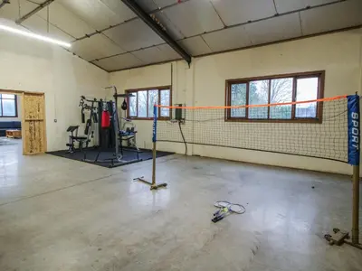 a gym with a tennis net in a room at Upper Home Farm in Church Stretton