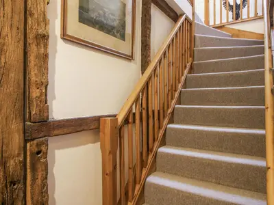 a set of stairs in a house with a picture on the wall at Upper Home Farm in Church Stretton