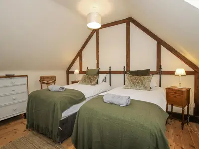 a bedroom with two beds with green and white sheets at Upper Home Farm in Church Stretton