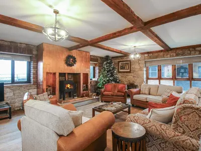a living room filled with furniture and a christmas tree at Upper Home Farm in Church Stretton