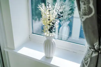 a white vase with flowers sitting on a window sill at Long Term Stay 3 Bed 1 Bath & Parking Shropshire in Oswestry