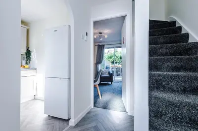 a hallway with a white refrigerator and a staircase at Long Term Stay 3 Bed 1 Bath & Parking Shropshire in Oswestry