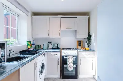a kitchen with white cabinets and a stove top oven at Long Term Stay 3 Bed 1 Bath & Parking Shropshire in Oswestry