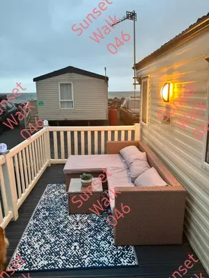 a patio with a couch and a table on a balcony at Sunset Walk 046 in Barmouth