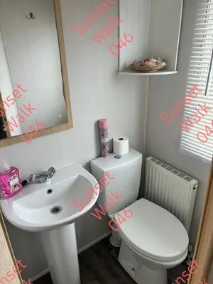 a bathroom with a sink and a toilet and a mirror at Sunset Walk 046 in Barmouth