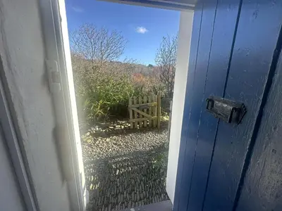 an open door with a view of a yard at Manteg in Aber-Arth