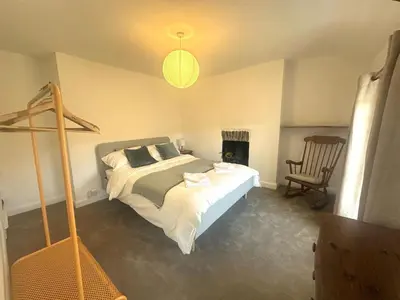 a bedroom with a large bed and a chair at Manteg in Aber-Arth