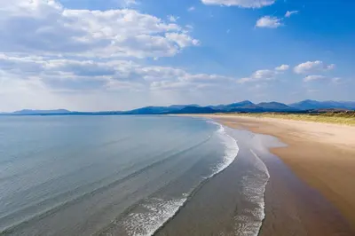a view of a beach with mountains in the background at Ty-Mari in Harlech