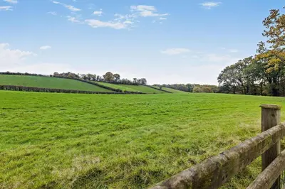 a field of green grass with a wooden fence at 1 Bed in Cilmery oc-g32770 in Builth Road
