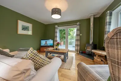 a living room with a couch and a tv at Erw-Fair in Arthog