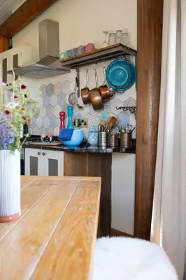 a kitchen with a wooden table in a room at Saffir Luxury Eco Lodge, log-fired bath & views in Dihewid