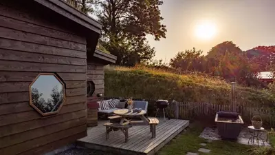 a backyard with a wooden deck with a fire pit at Saffir Luxury Eco Lodge, log-fired bath & views in Dihewid