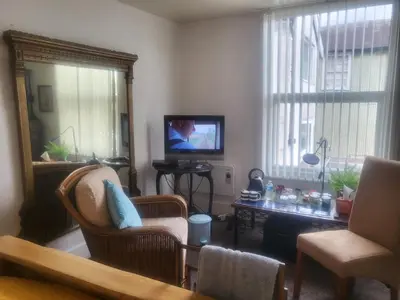 a living room with a tv and chairs and a mirror at 23a High Street Knighton in Knighton