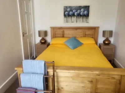 a bedroom with a yellow bed and a chair at 23a High Street Knighton in Knighton