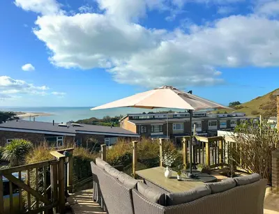 a patio with a table with an umbrella at Terrace by the Tide in Aberdyfi