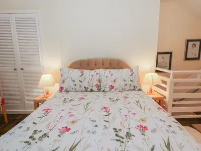 a bedroom with a bed with a floral bedspread at 6 Church Lane in Llanidloes