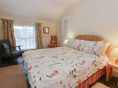 a bedroom with a bed with a floral bedspread at 6 Church Lane in Llanidloes