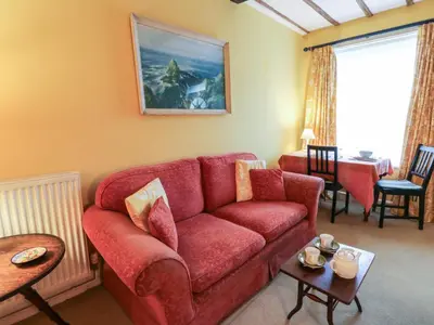 a living room with a red couch and a table at 6 Church Lane in Llanidloes