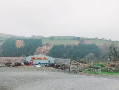a building with a sign on the side of a road at Deer Cabin-hot tub-dog friendly-mountain view in Llanbrynmair