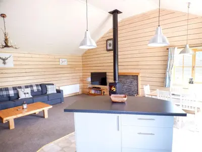 a kitchen and living room with a stove at Deer Cabin-hot tub-dog friendly-mountain view in Llanbrynmair