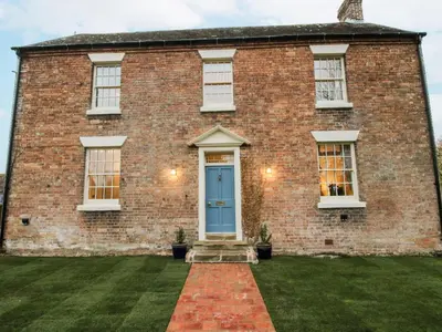 a large brick house with a blue door at Highfields Farm in Church Stretton